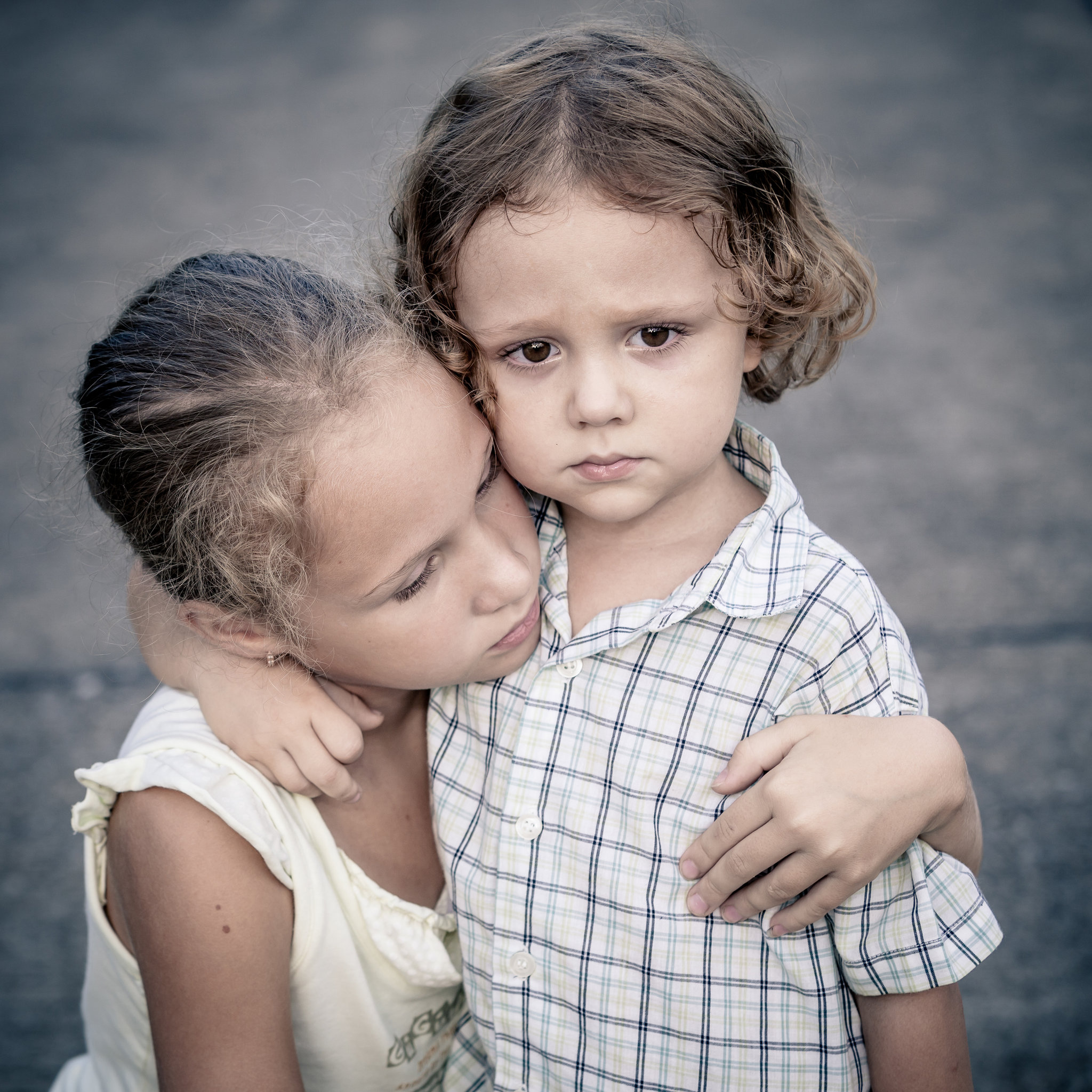 Portrait of sad teen girl and little boy at the day time